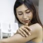 Young Asian woman with healthy skin applying sunscreen UV protect to shoulder.