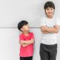 Little child boy standing arms crossed and looking face of tall child at standing arms crossed and smiling. Big and small kid concept at be friends.